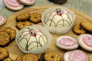 Dessert in the form of cakes with funny spiders. Soufflé cake and cookies on a wooden board. Dessert close-up.