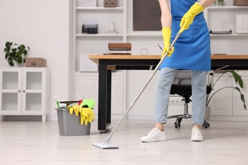 Cleaning service worker washing floor with mop, closeup. Bucket with supplies in office