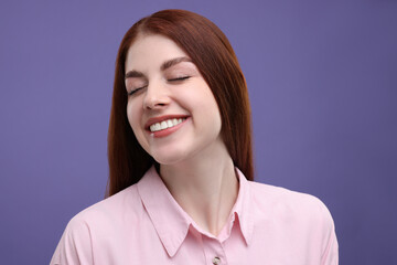 Fototapeta premium Portrait of smiling woman with freckles on purple background