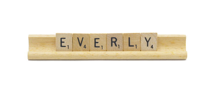 Miami, FL 4-18-24 popular baby girl first name of EVERLY made with square wooden tile English alphabet letters with natural color and grain on a wood rack holder isolated on white background