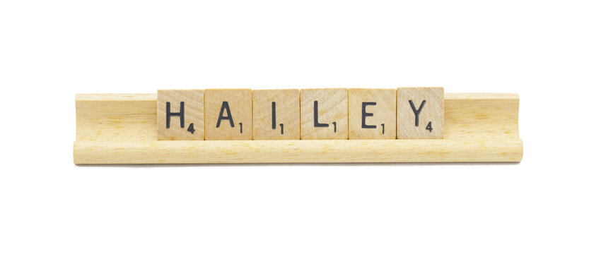 Miami, FL 4-18-24 popular baby girl first name of HAILEY made with square wooden tile English alphabet letters with natural color and grain on a wood rack holder isolated on white background