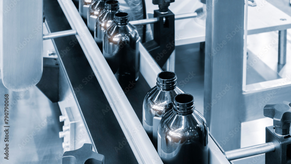 Poster a conveyor belt with bottles on it. the bottles are all the same color and are lined up