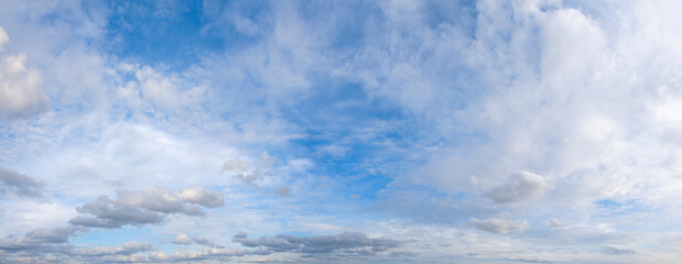 The sky is blue with a few clouds scattered throughout. The clouds are white and fluffy, giving the...
