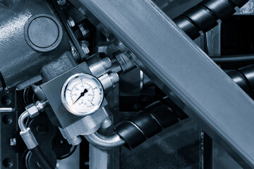 A close up of a pressure gauge on a machine. The gauge is white and black and has a black face