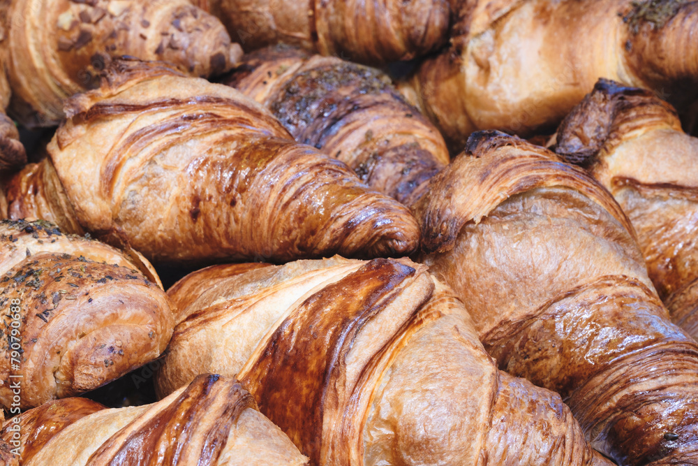 Poster a stack of croissants with a variety of toppings. the croissants are golden brown and appear to be f
