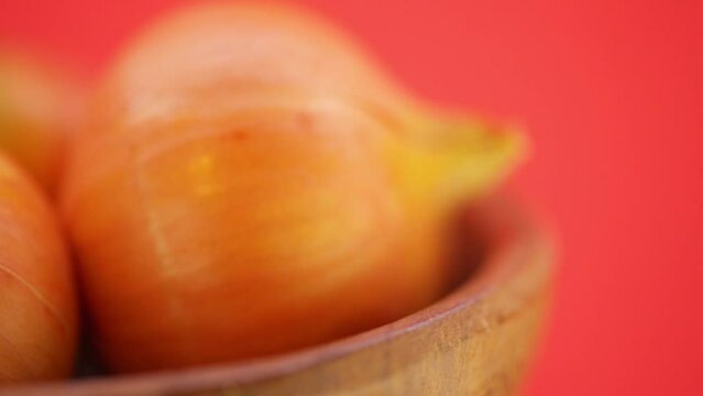 Brown onions in wooden plate