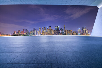 Empty square floors and city skyline with modern buildings at night