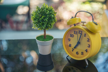 Alarm clock Red vintage retro time on book and tree green nature bokeh nature deadline concept.