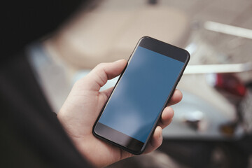 Hand holding a mobile phone mockup with a blank screen