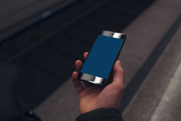 Hand holding a mobile phone mockup with a blank screen