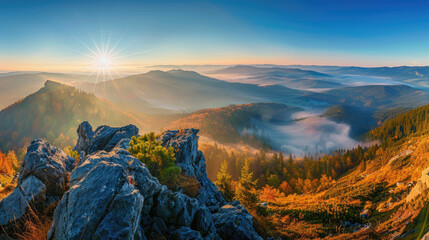 Obraz premium Panoramic view from autumn mountain peak at sunrise in blue sky with misty valley below