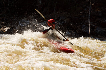 A Person In A Red Kayak Is Paddling Through A River
