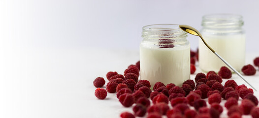 Homemade yogurt with raspberries. Jars of yogurt surrounded by raspberries