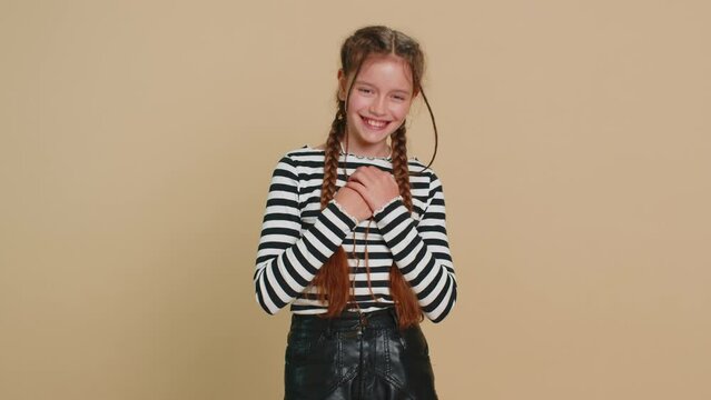 Happy preteen child girl kid laughing out loud after hearing ridiculous anecdote, reaction on funny joke feeling carefree amused. Positive people. Teenager children isolated on studio beige background