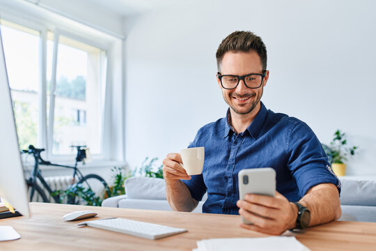 Adult man using mobile phone while working from home