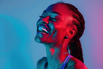 Happy African American woman in front of vibrant blue and red lights, laughing and smiling in delight