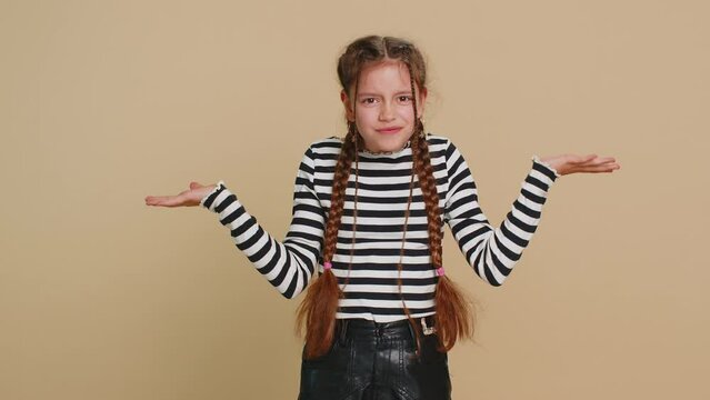 What. Why. Young school girl raising hands in indignant expression asking why what reason of failure, demonstrating disbelief irritation by troubles. Preteen child kid 10 years old on beige background