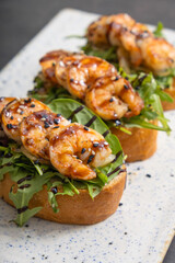 Close up toast with fried shrimp and salad mix. Delicious snacks with seafood