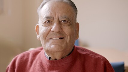 Old man smiling at camera sitting in nursing home