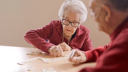 Senior people playing dominoes patiently in nursing home