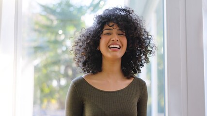 Beauty african woman with curly hair laughing at camera