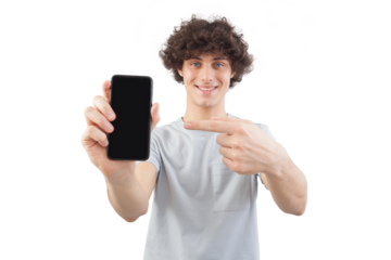 Smiling and handsome, the young man showing the blank screen of his smartphone to the camera pointing display with finger while looking to the camera with his blue eyes, isolated on white background