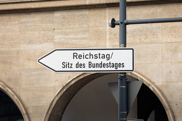 Reichstag and Sitz des Bundestages sign (German parliament). Arrow shape in the direction of the...