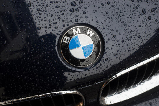 Strasbourg - France - 19 April 2024 - Closeup of rain drops of BMW logo on black car front parked in the street