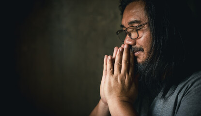Man hand in prayer, expressing his religious faith in God through worship of Jesus Christ. Person...