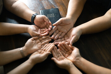 Woman gathered with her Christian friends in church, Bible close as they joined in prayer, feeling warmth of their religious family bond within group. - obrazy, fototapety, plakaty