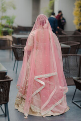 Stunning Indian bride dressed in Hindu traditional wedding clothes lehenga embroidered with gold...