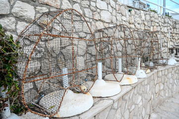 Fish traps on the wall by the sea.  Sea fishing. Wire mesh fish trap in the water. 