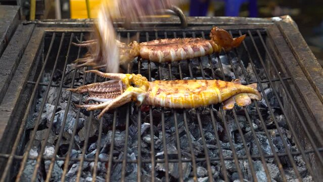 Grill delicious fresh squid, grill squid on a pink scale