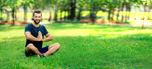 Portrait of brunette bearded man coach practicing yoga, sit in half lotus exercise, ardha padmasana...