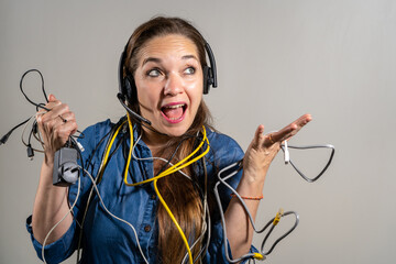 Mujer sosteniendo un montón de cables en expresión de problemas con la tecnología.  Fotografía de estudio con fondo blanco