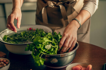 person preparing a bowl of fresh greens, emphasizing the farm-to-table connection and the beauty of...