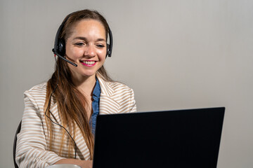 Mujer oficinista en una telellamada usando su laptop.