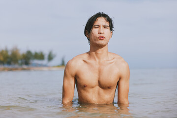 Serene Summer Splash: Active Asian Man Swimming in Tropical Ocean on Vacation