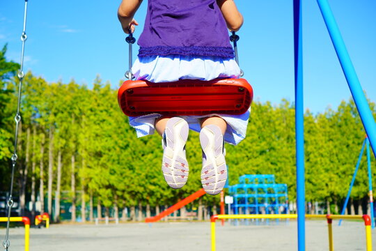 公園でブランコに乗っている小学3年生の女の子の足元