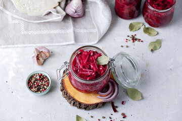Fermented vegetables cabbage with carrot and beetroot in glass jar, grey background. Flat lay.