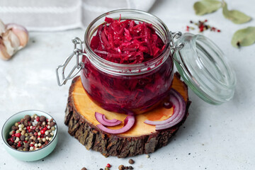 Fermented vegetables cabbage with carrot and beetroot in glass jar, grey background. Flat lay.