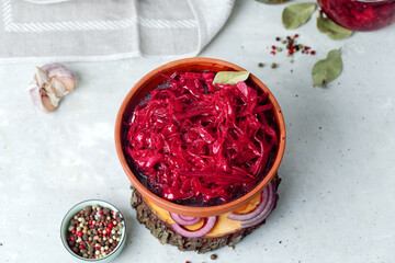 Fermented vegetables cabbage with carrot and beetroot in clay bowl, grey background. Flat Lay.