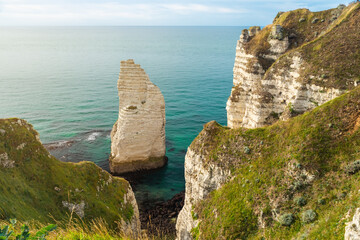 White chalk cliffs and natural arches of Etretat, Normandy, France. French sea coast in Normandie with famous rock formations at sunset. Travel destination