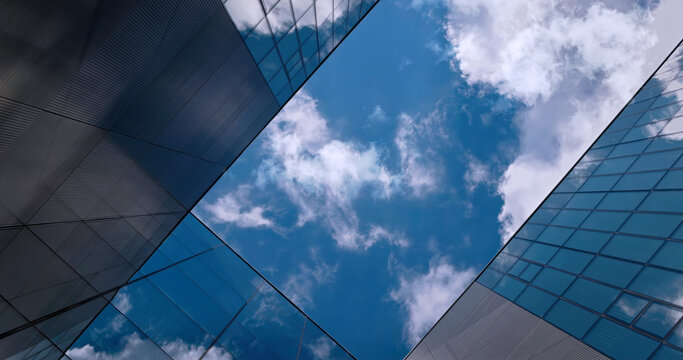 Up view between glass metal office buildings, corporation business skyscrapers, clouds sky. Looking up at modern downtown financial office architecture. City real estate background, minimalist design