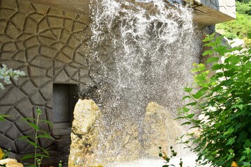 Beautiful fountain in the form of a waterfall in a city park