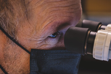Scientist looking through a microscope 