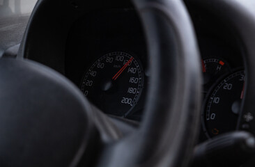 steering wheel and speedometer in the cockpit of a simple car