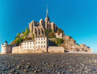 Mont Saint Michel abbey on the island during low tide, Normandy, Northern France, Europe. Tidal island with medieval gothic cathedral in Normandie. Travel and touristic destination