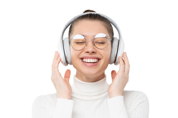 Young female with closed eyes, wearing glasses and wireless headphones, enjoying listening to music...
