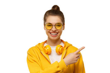 Laughing girl wearing yellow headphones around neck, pointing right